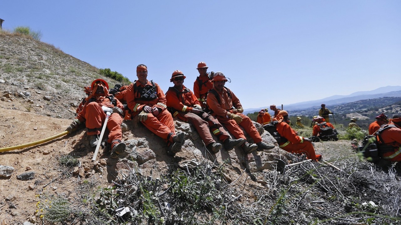 Firefighters take a break on a hillside after hours of work Thursday, May 15, 2014, in San Marcos, Calif.