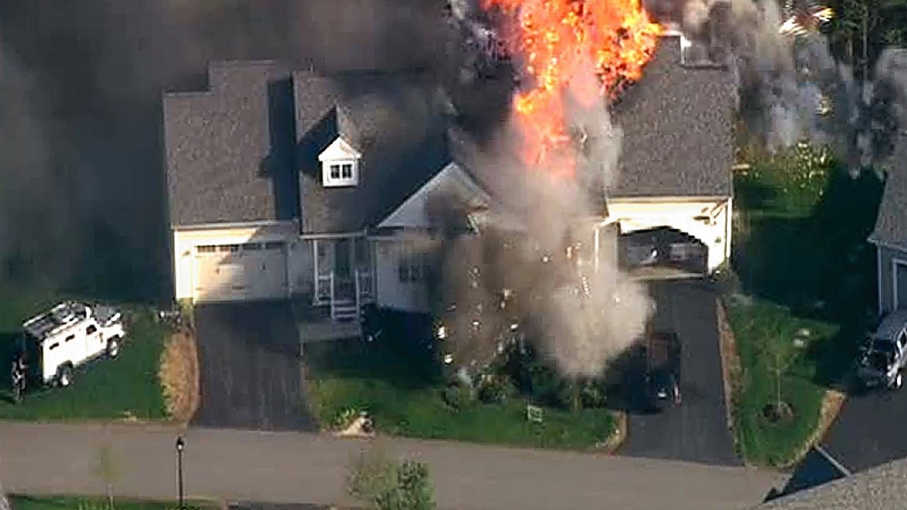 Local US TV images after a New Hampshire police officer was shot to death after he responded to a domestic disturbance at a home that later exploded and burned