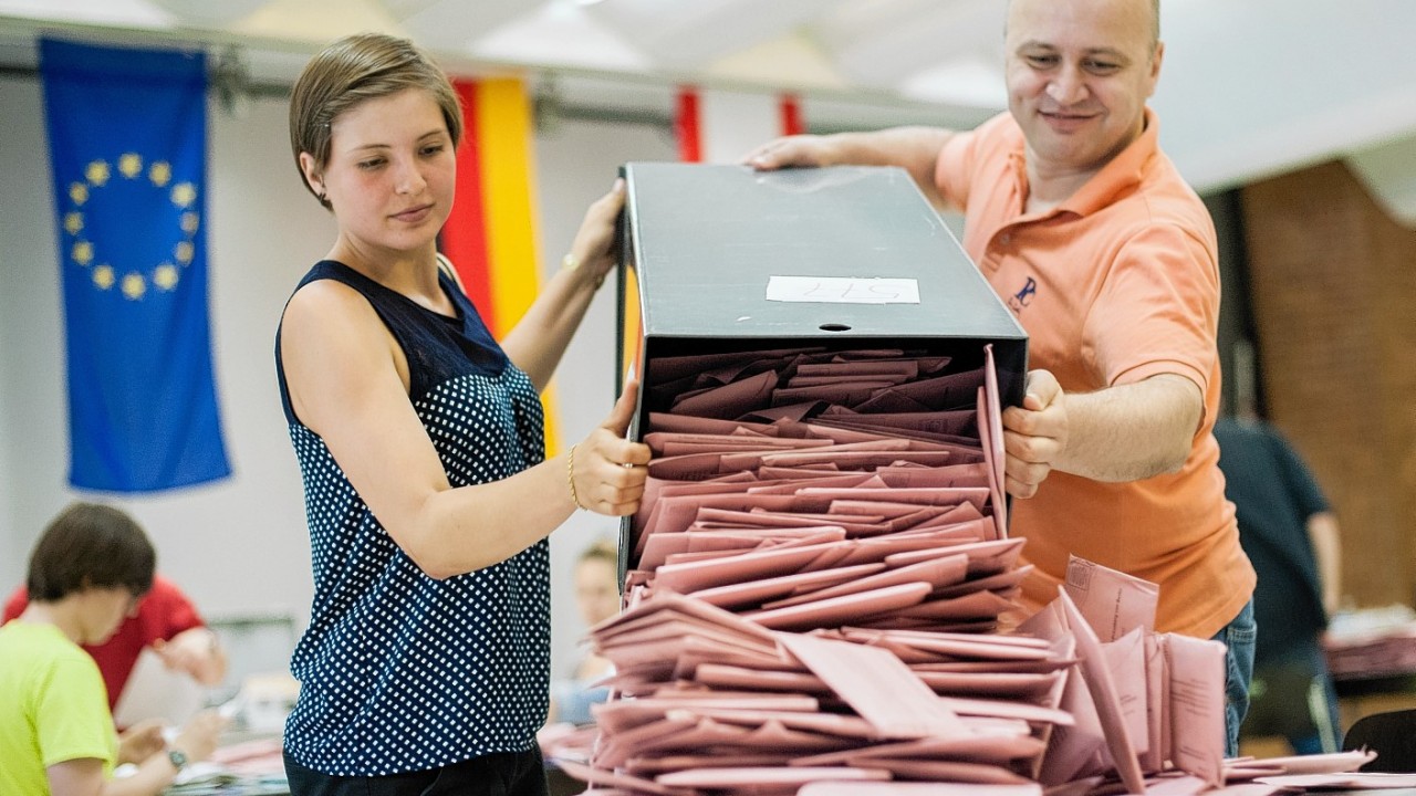 Poll workers empty an urn with postal votes for the European elections in Berlin, Germany,
