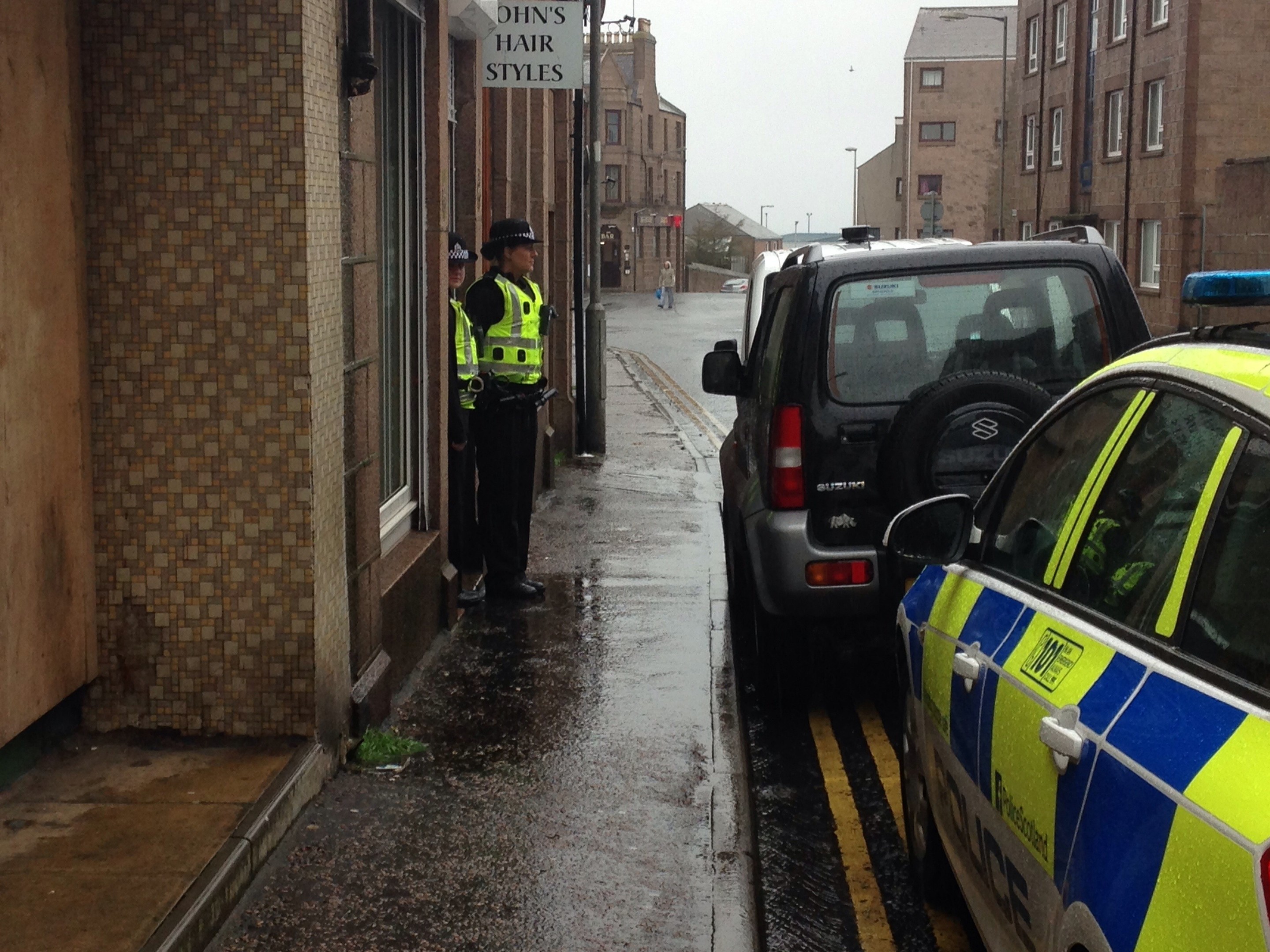 Police guard the entrance to the raided shop in Peterhead