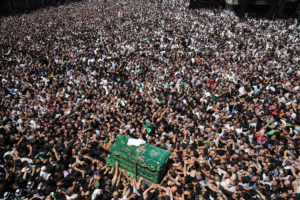 Shiite pilgrims carry a symbolic coffin at the holy shrine of the Imam Moussa al-Kadhim during the annual commemoration of the saint's death at Kazimiyah district of Baghdad, Iraq, Sunday, May 25, 2014.