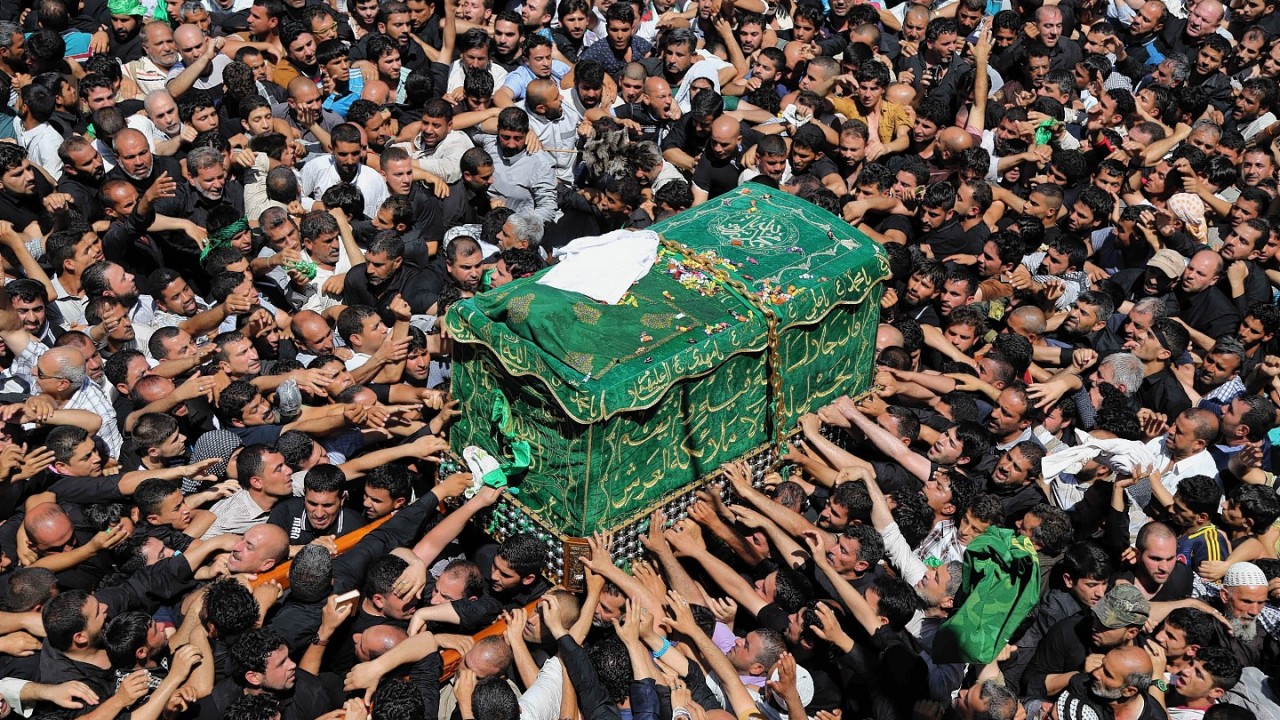 Shiite pilgrims carry a symbolic coffin at the holy shrine of the Imam Moussa al-Kadhim during the annual commemoration of the saint's death at Kazimiyah district of Baghdad, Iraq, Sunday, May 25, 2014
