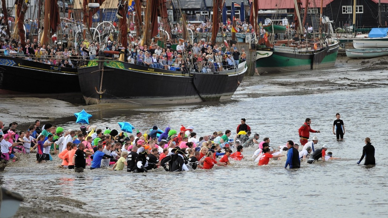 Competitors take part in the Maldon Mud Race, a charity event on the River Blackwater in Maldon, Essex