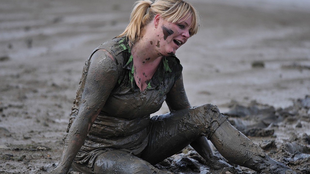 A competitor takes part in the Maldon Mud Race, a charity event on the River Blackwater in Maldon, Essex