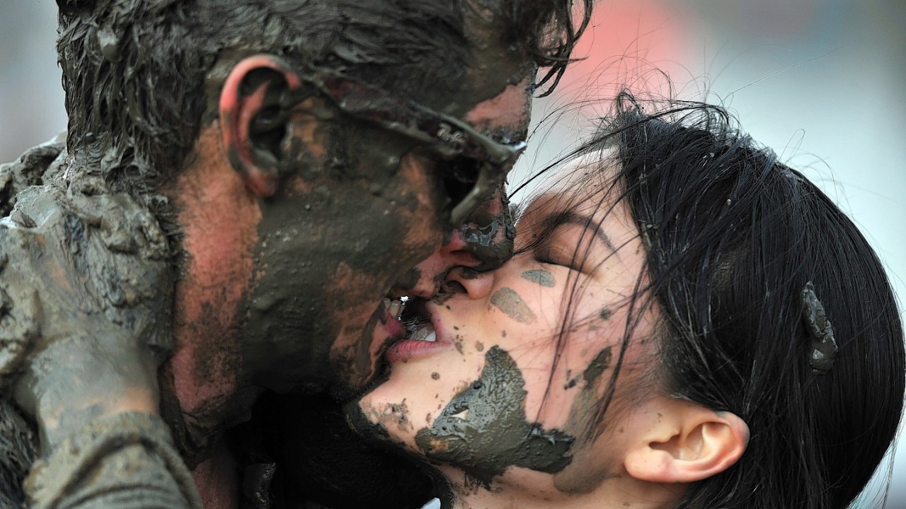 Competitors kiss after taking part in the Maldon Mud Race, a charity event on the River Blackwater in Maldon, Essex.