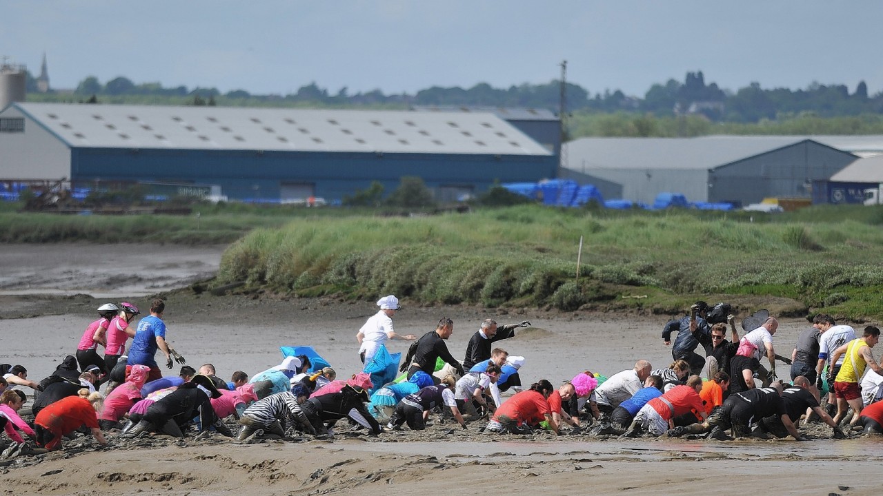 Competitors take part in the Maldon Mud Race, a charity event on the River Blackwater in Maldon, Essex