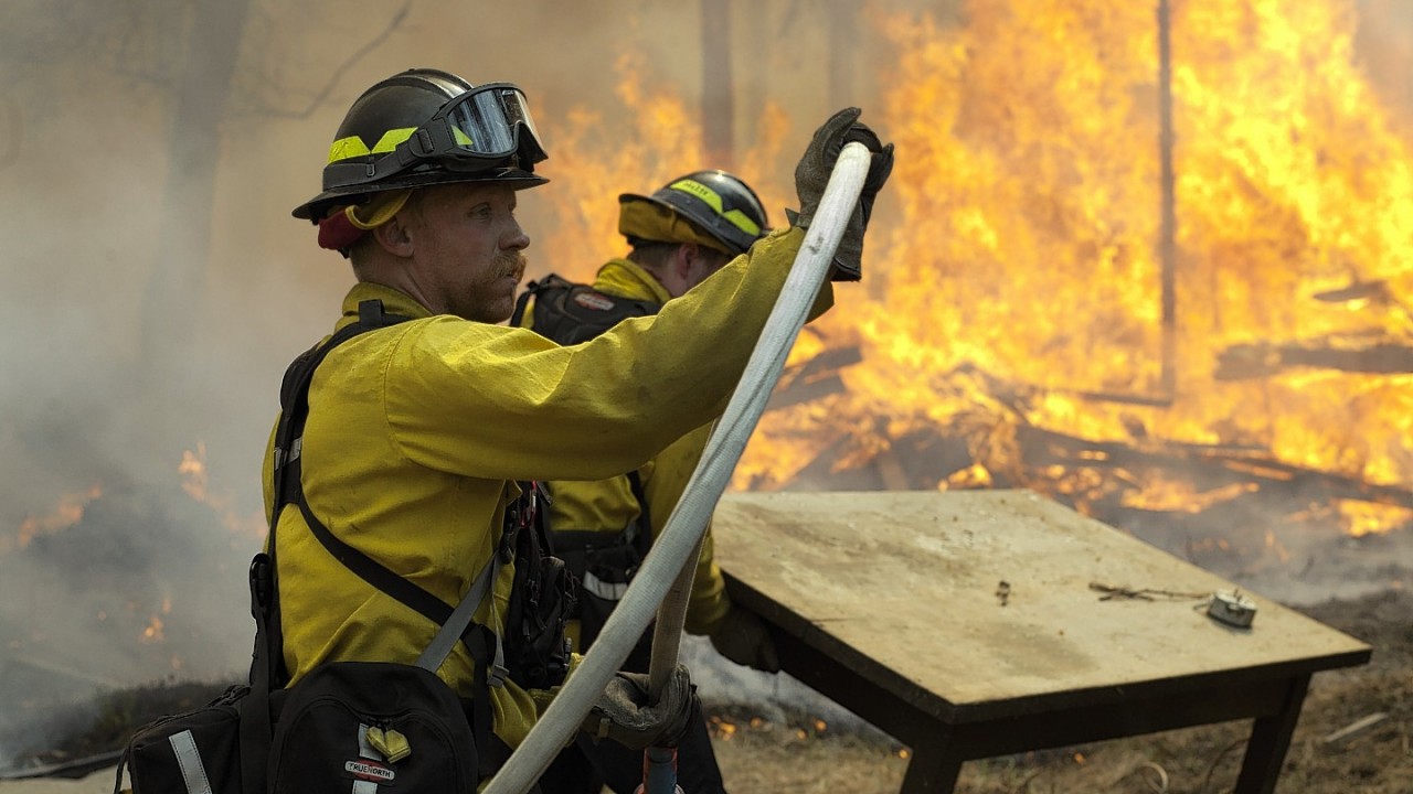Central Emergency Services firefighter Dan Jensen maneuvers a hose into position to fight a portion of a wildfire Sunday, May 25, 2014, in the Funny River community of Soldotna, Alaska