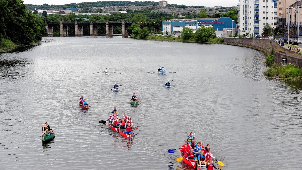 The baton travels down the river Dee in a canoe flotilla.