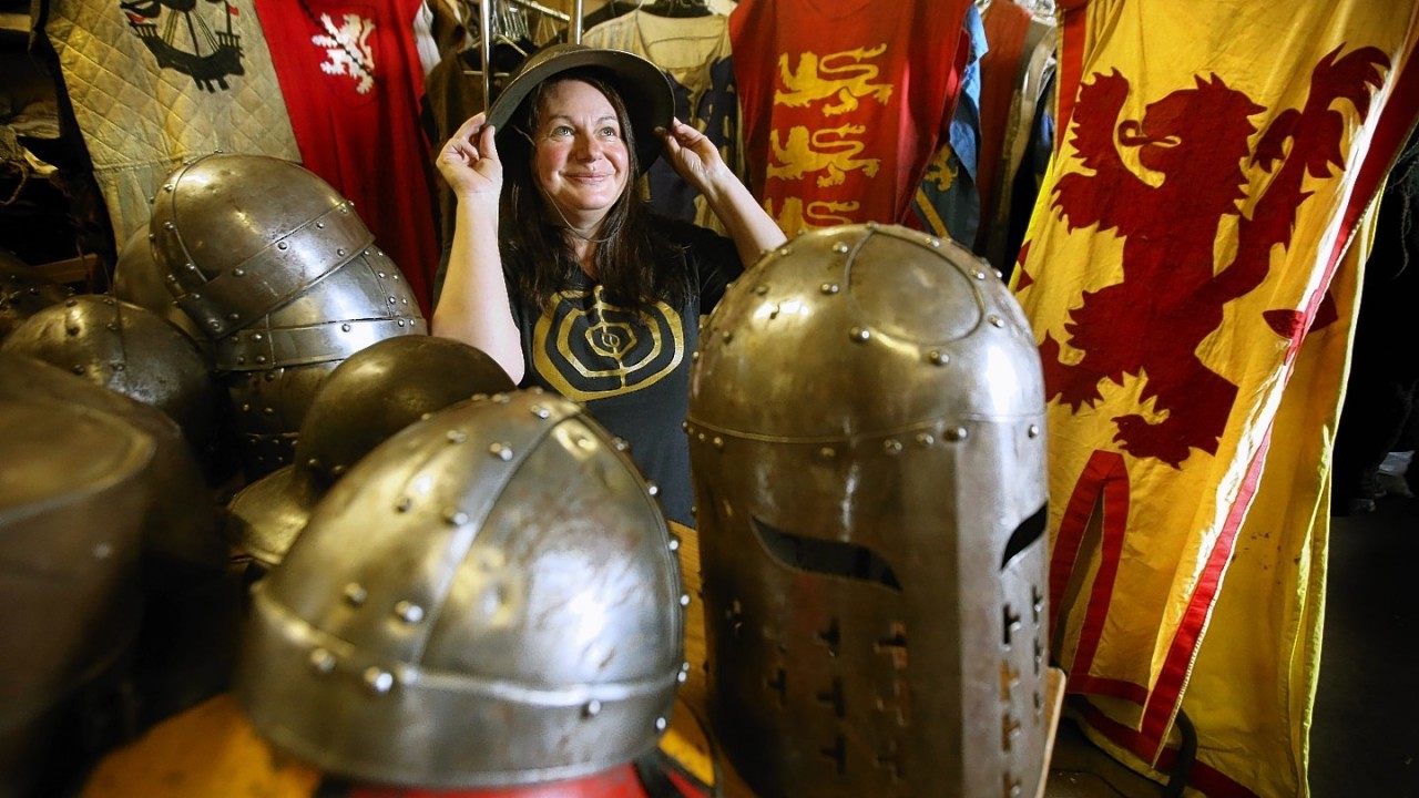 Annette Grier from the Clanranald Trust tries on a helmet as she lines, polishes and fixes straps to helmets along with making adjustments to costumes during final preparations for the Battle of Bannockburn performance being held at Bannockburn Live Event in Bannockburn on the 28th and 29th June as the Battle of Bannockburn's 700th anniversary is celebrated.