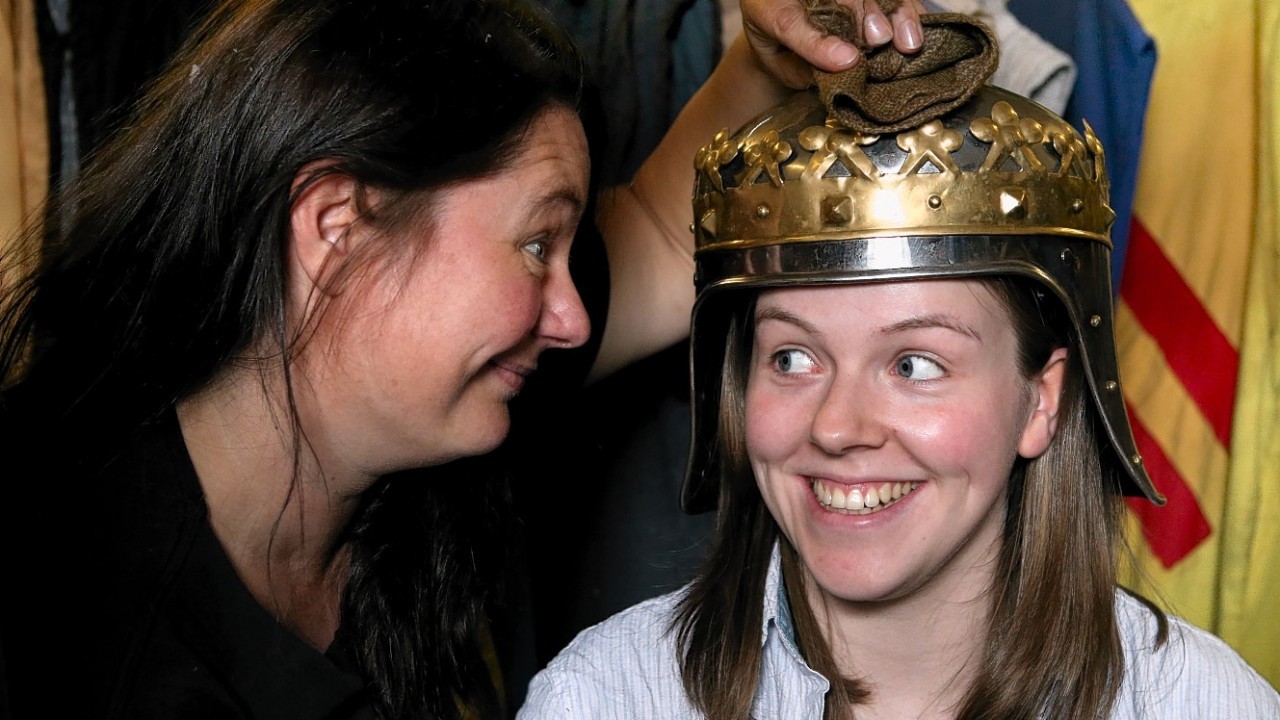 Linda McDade from the Clanranald Trust wears a replica Robert the Bruce helmet as fellow trust member Annette Grier gives it a polish during final preparations for the Battle of Bannockburn performance being held at Bannockburn Live Event in Bannockburn on the 28th and 29th June as the Battle of Bannockburn's 700th anniversary is celebrated.