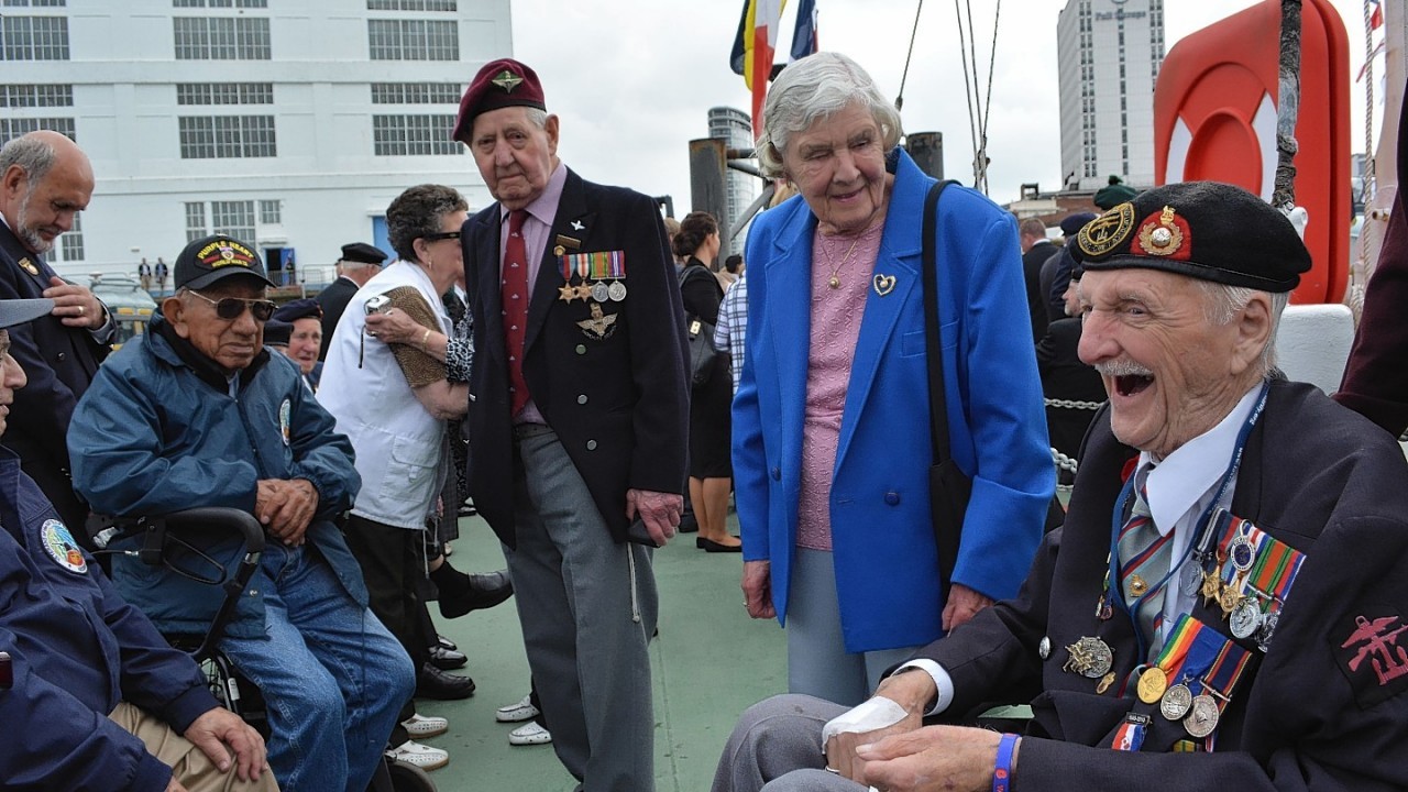Jim Baker, 91, (right) from Blackpool, who landed on Juno Beach as a Royal Marine Commando on D-Day, laughs as he meets US veterans during a visit to the Portsmouth Historic Dockyard ahead of the 70th anniversary of the D-Day campaign.