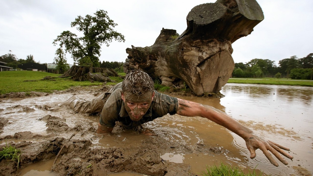 Blair Drummond Safari Park keeper Graeme Alexander crawls through rhinos' mud wallow as he trains for the Tough Mudder Challenge