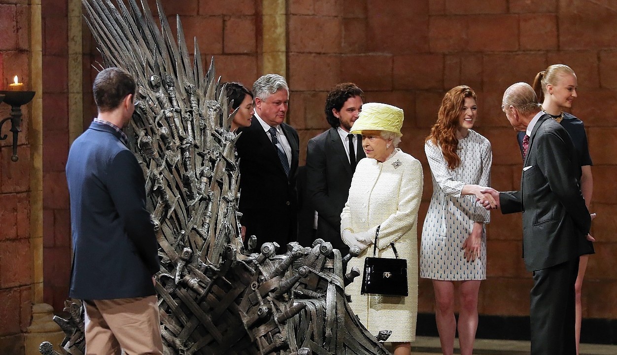 Queen Elizabeth II meets cast members of the HBO TV series 'Game of Thrones' Lena Headey and Conleth Hill as she views some of the props including the Iron Throne on the set of Game of Thrones in Belfast's Titanic Quarter