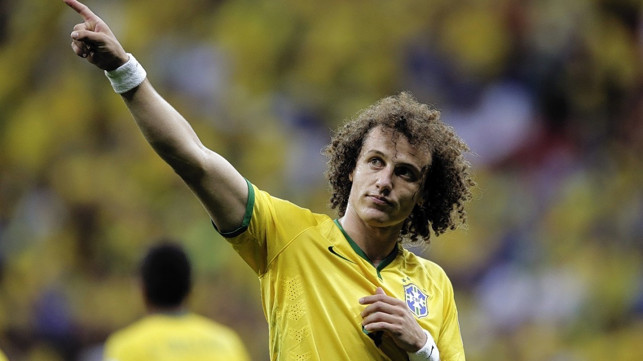 Brazil's David Luiz points to spectators following Brazil's 4-1 victory over Cameroon in the group A World Cup soccer match between Cameroon and Brazil at the Estadio Nacional in Brasilia