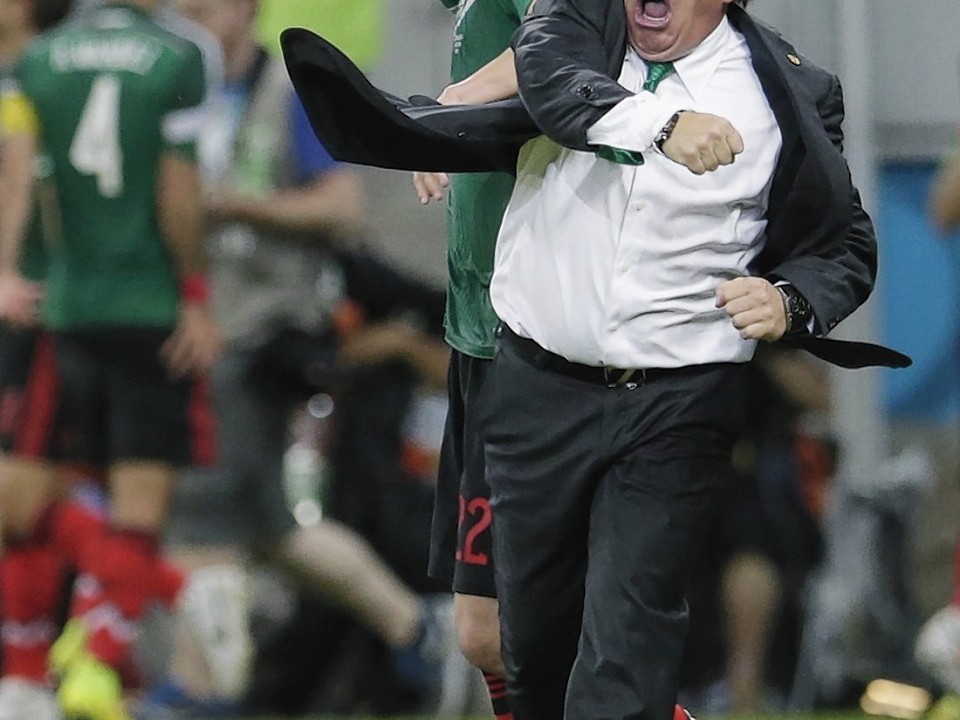 Mexico's head coach Miguel Herrera celebrates after Mexico's Andres Guardado  scored his side's second goal during the group A World Cup soccer match between Croatia and Mexico at the Arena Pernambuco in Recife