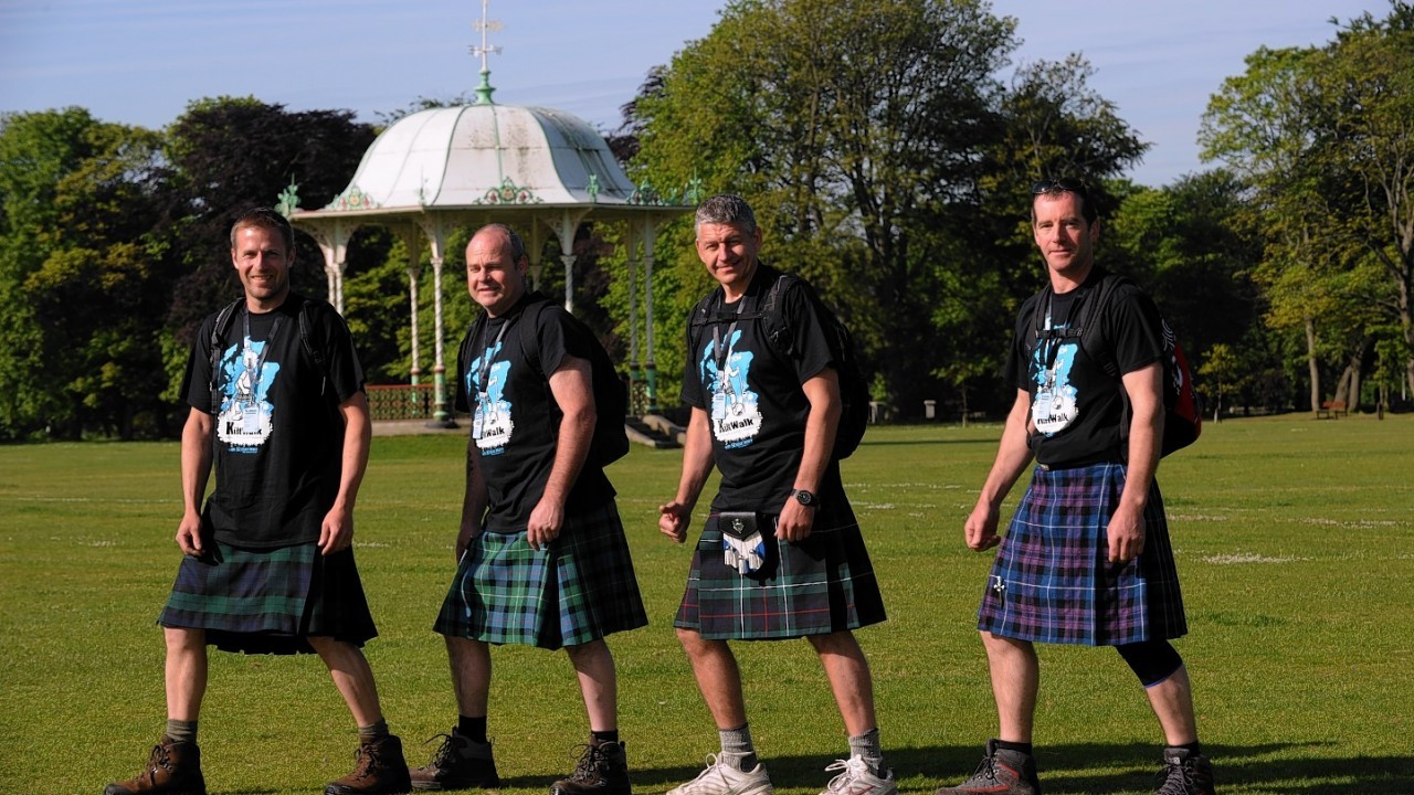 Four men in kilts in front of the Duthie Park bandstand 