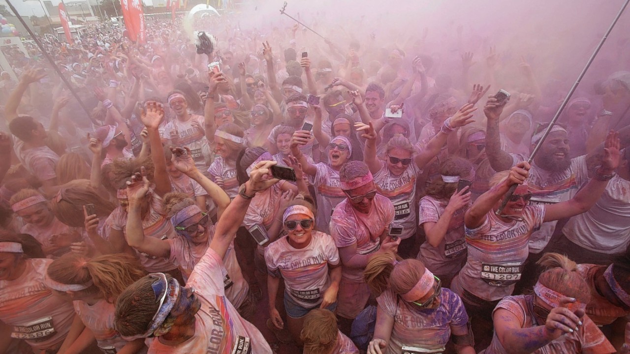 Runners take part in The Color Run in Wembley, London, a 5k run where at each kilometre, colour explosions of powder made from cornstarch cover the runners.