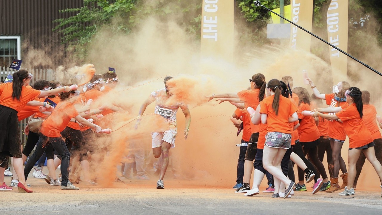 Runners take part in The Color Run in Wembley, London, a 5k run where at each kilometre, colour explosions of powder made from cornstarch cover the runners.