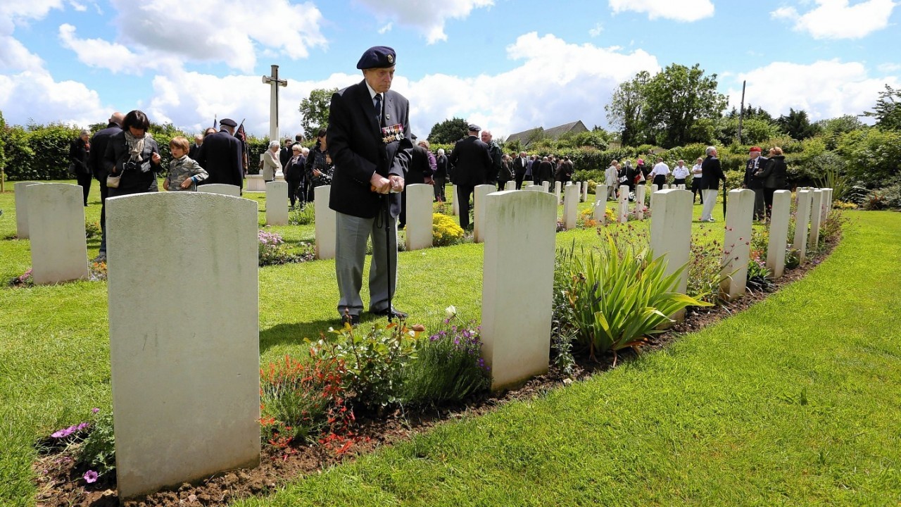 A member of the Normandy Veterans Association takes time to view the headstones at Jerusalem Cemetery in Chouain, France, during a commemorative ceremony to mark 70th anniversary of the D-Day landings during World War II.