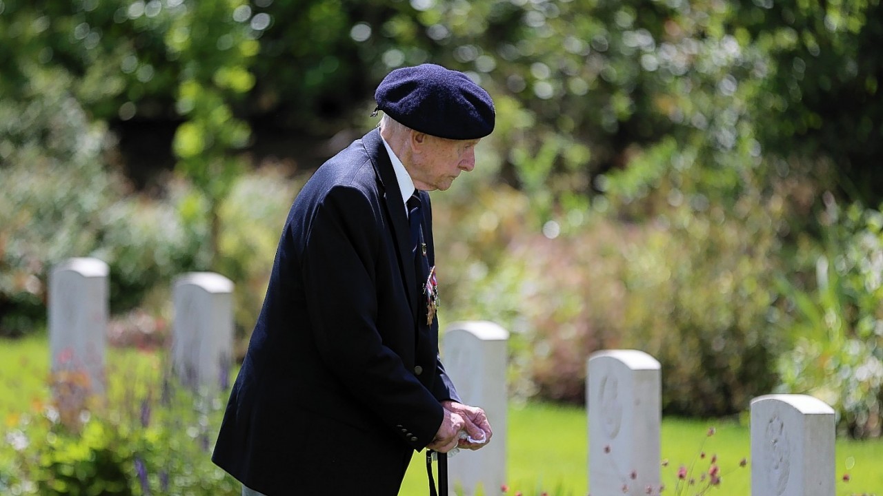 A member of the Normandy Veterans Association takes time to view the headstones at Jerusalem Cemetery in Chouain, France, during a commemorative ceremony to mark 70th anniversary of the D-Day landings during World War II.