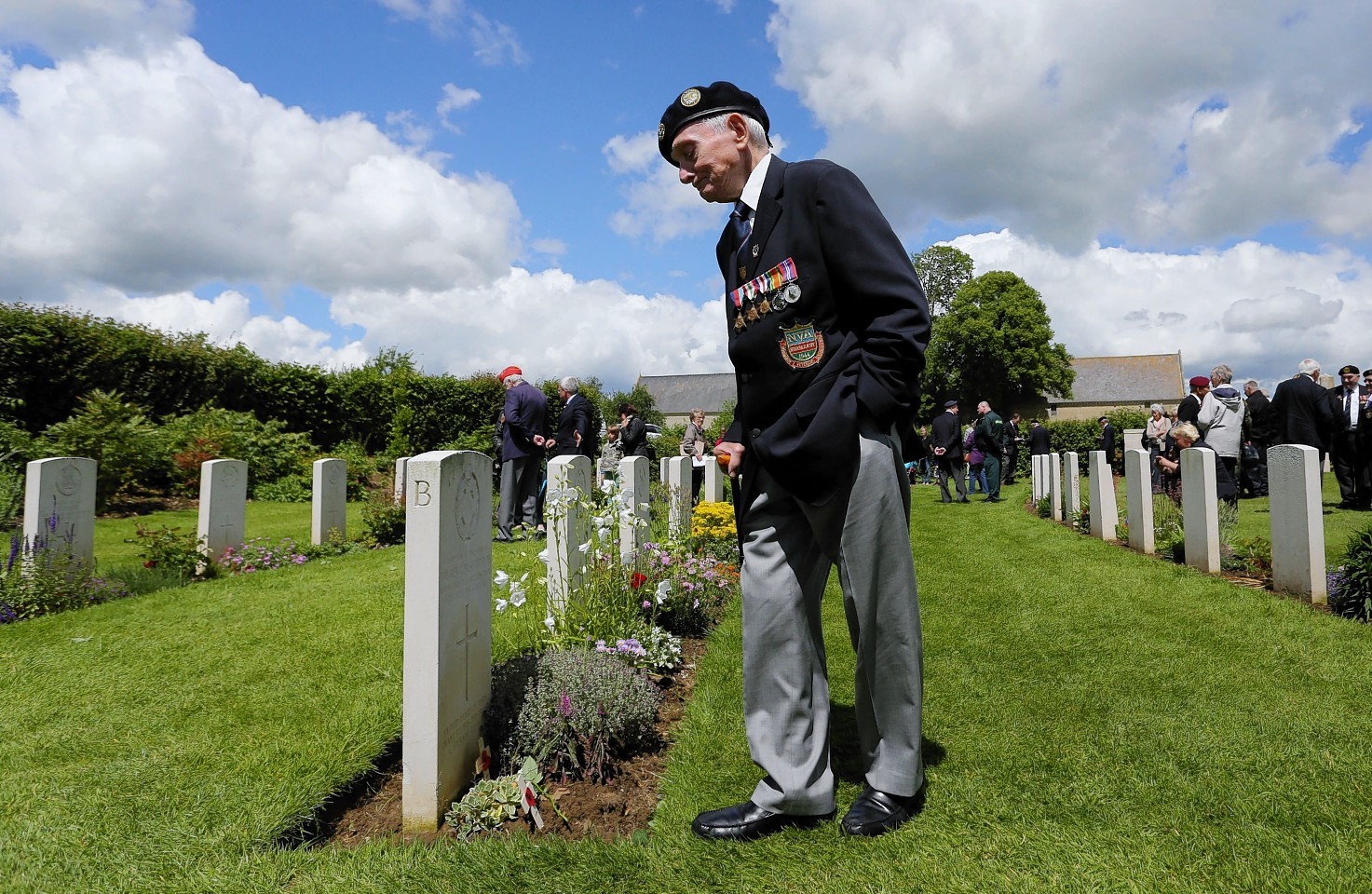 A member of the Normandy Veterans Association takes time to view the headstones at Jerusalem Cemetery in Chouain, France, during a commemorative ceremony to mark 70th anniversary of the D-Day landings during World War II.