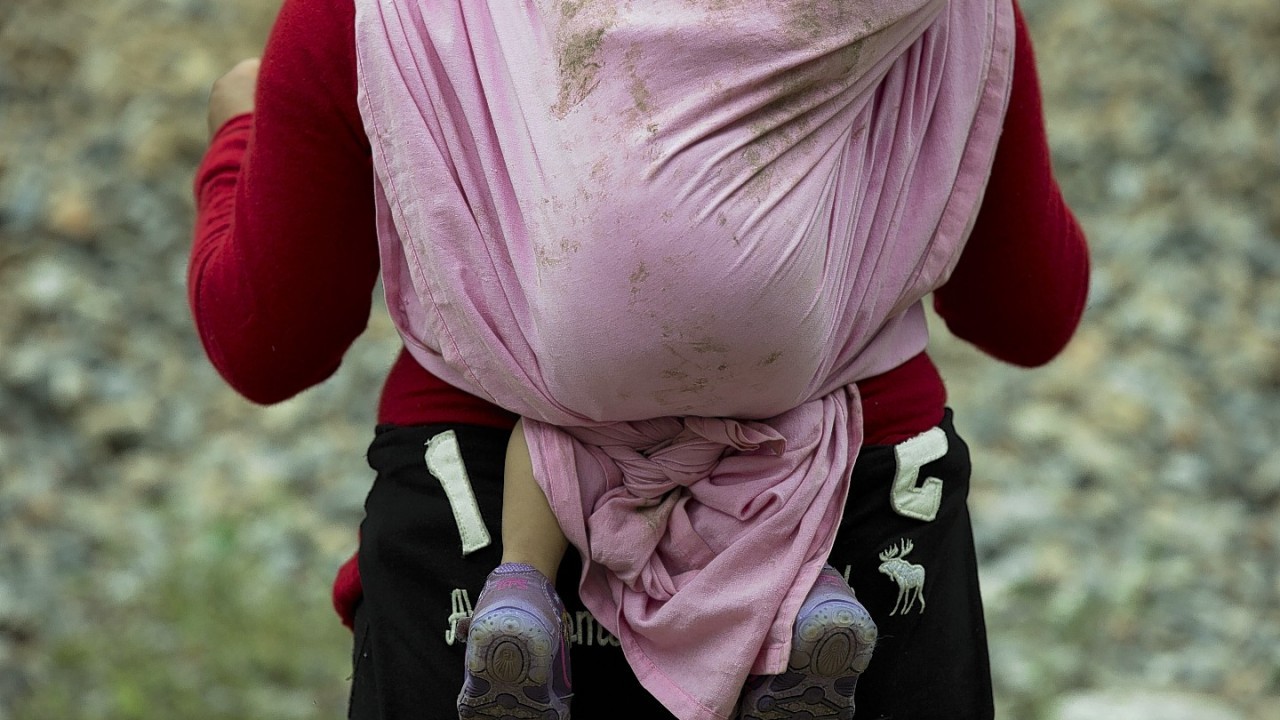 a Central American migrant carrying a small child waits alongside a stuck northbound freight train, outside Reforma de Pineda, Chiapas state, Mexico. The migrants faith that children will be allowed to stay in the U.S. isn't totally misplaced. While Mexicans are usually returned across the border quickly when they're caught, overwhelmed border facilities are unable to care for most Central American children. Minors crossing the border alone are generally released into the care of relatives already in the U.S., while mothers with children are generally let go with a notice to reappear later in immigration court.