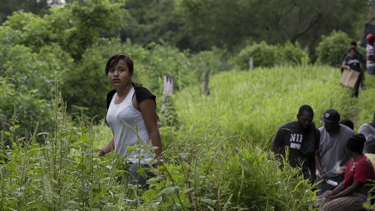 Guatemalan migrant Gladys Chinoy, 14, waits along with more than 500 other migrants, after the freight train they were traveling on suffered a minor derailment, leaving them stranded for more than 12 hours in a remote wooded area outside Reforma de Pineda, Chiapas state, Mexico. On the last day of middle school, Chinoy memorized her mother's phone number in New York City and boarded a bus to Guatemala's northern border. Once across the river into Mexico, she joined a group of women and children traveling with a smuggler paid to take migrants to the U.S.