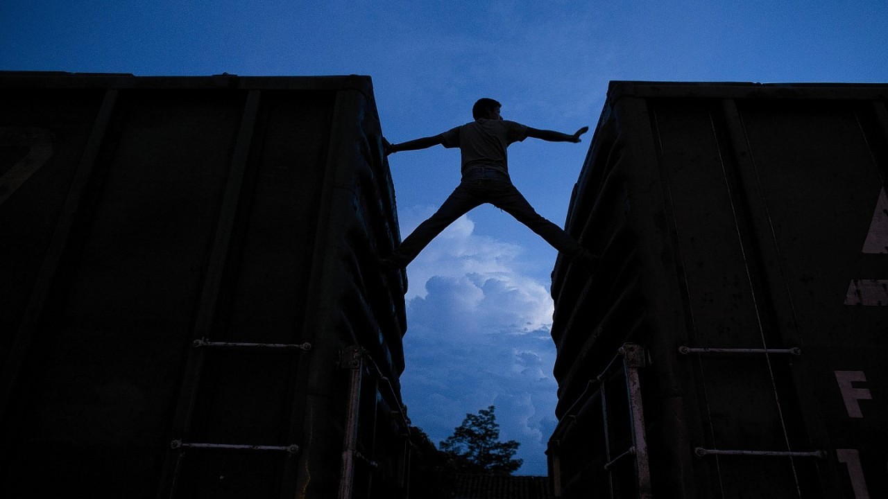 a Central American migrant practices scaling parked boxcars, as he awaits the arrival of a northbound freight train in Arriaga, Chiapas state, Mexico. The number of unaccompanied minors detained on the U.S. border has more than tripled since 2011. Children are also widely believed to be crossing with their parents in rising numbers, although the Obama administration has not released year-by-year figures.