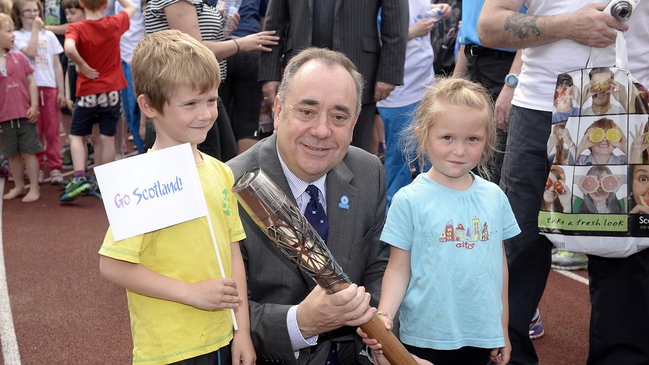 Scotland's First Minister Alex Salmond with Craig Burns (aged seven) and Marilee Burns (aged five) and the Glasgow 2014 Queen's Baton at Meadowbank Stadium in Edinburgh. (Ben Birchall for Glasgow 2014)