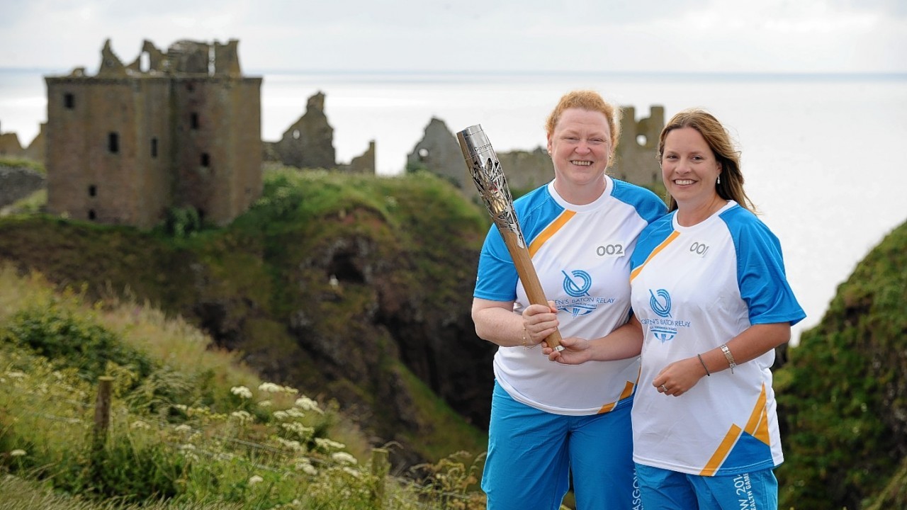 The Glasgow 2014  Commonwealth Games Queens Baton Relay.
Batonbearers Professor Sue Black and Lisa Singleton carrying the Queen's Baton at Dunnottar Castle.