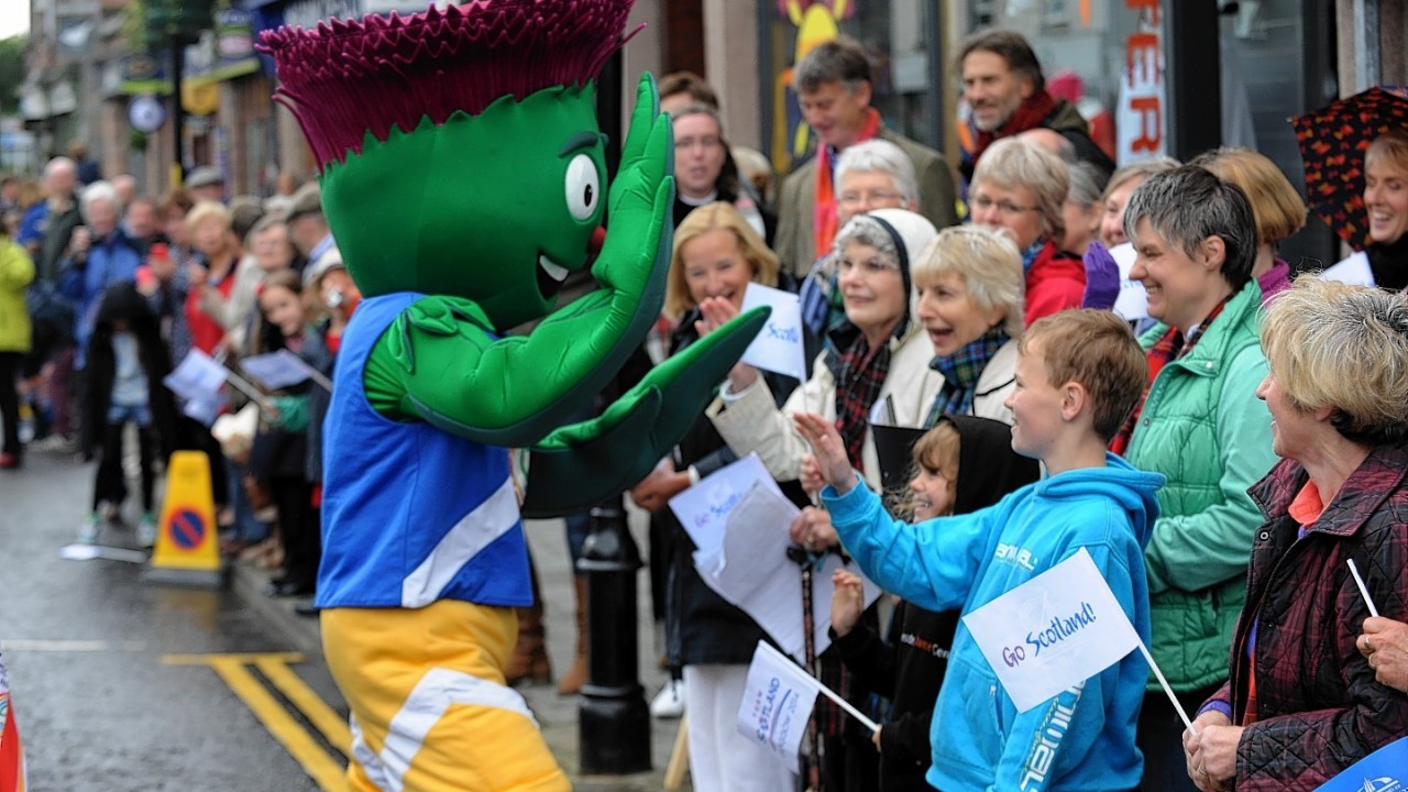 The Glasgow 2014  Commonwealth Games Queens Baton Relay.
Picture of crowds lining the street of Banchory.