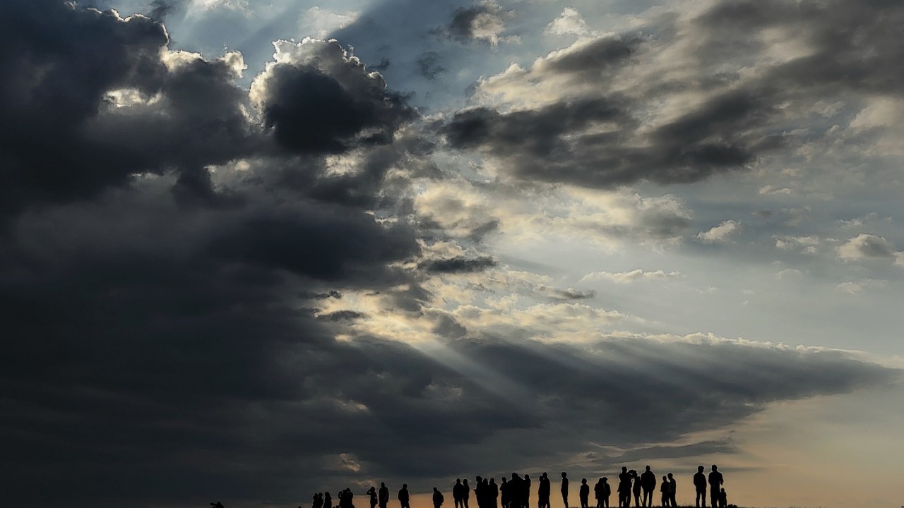 Spectators watch under heavy clouds the a landing of  solar-powered Solar Impulse 2 aircraft  after its first flight
