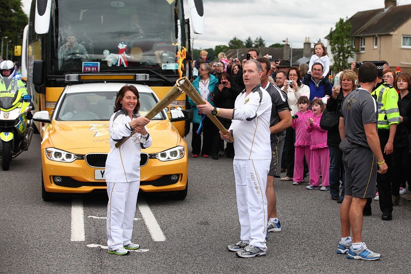 Peter Bruce receives the Olympic flame from wife Roselyn in 2012