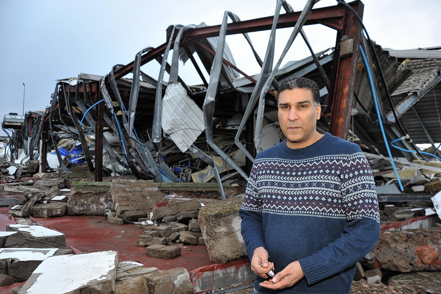 Nasar Rashid in front of his ruined factory