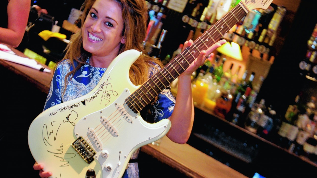 Sarah-Jane Hogg with a signed guitar from Snow Patrol, which went for £2,200 in the main auction.