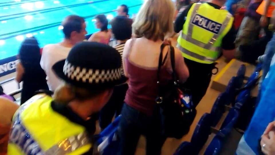 The woman is escorted from the arena by police