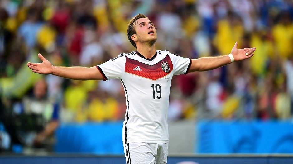 Mario Gotze holding his arms out and looking to the sky on the pitch