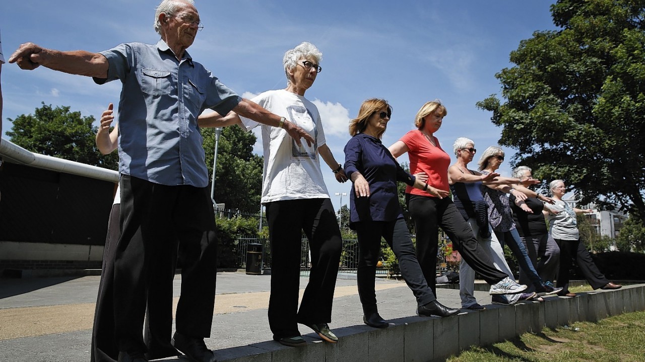 George Jackson, 85, left, an army veteran and former boxer, Lara Thomson 79, 2nd left, and others participate at a parkour class for elderly people.