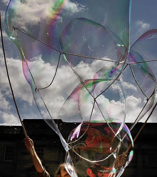 Mr Bubbles, one of the Edinburgh Fringe Festival acts, blowing bubbles in front of a crowd of members of the public in Edinburgh's Royal Mile ahead of the start of the festival this week