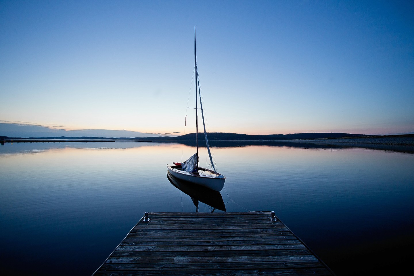 A sail boat is  tied to a landing stage at Lake  Brombachsee near Pleinfeld,  southern Germany. Weather forecasts predict changeable weather