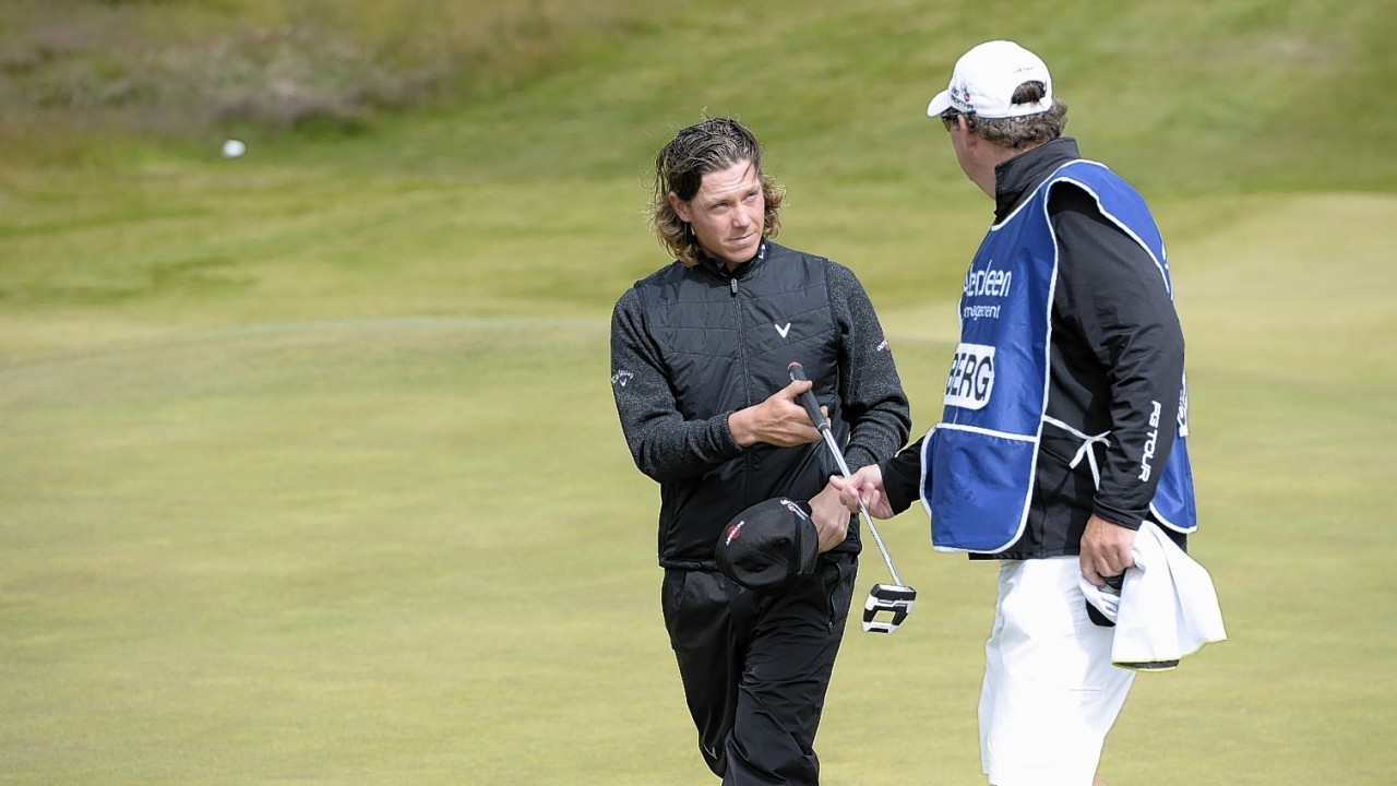 Morning leader Kristoffer Broberg (left) takes on advice from his caddy