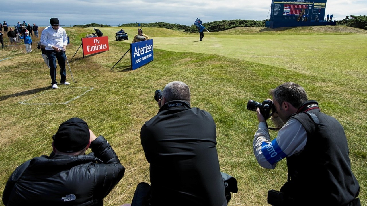 Photographers and fans look on as Scotland's Russell Knox is given a free drop shot on the 18th Leader