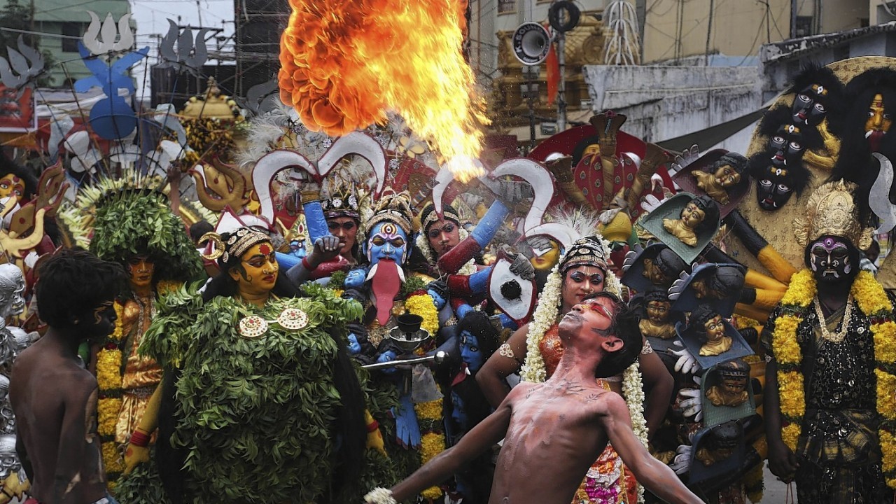 An Indian artist performs with fire during a procession as part of "Bonalu", a Hindu folk festival, in Hyderabad, India, Monday, July 21, 2014