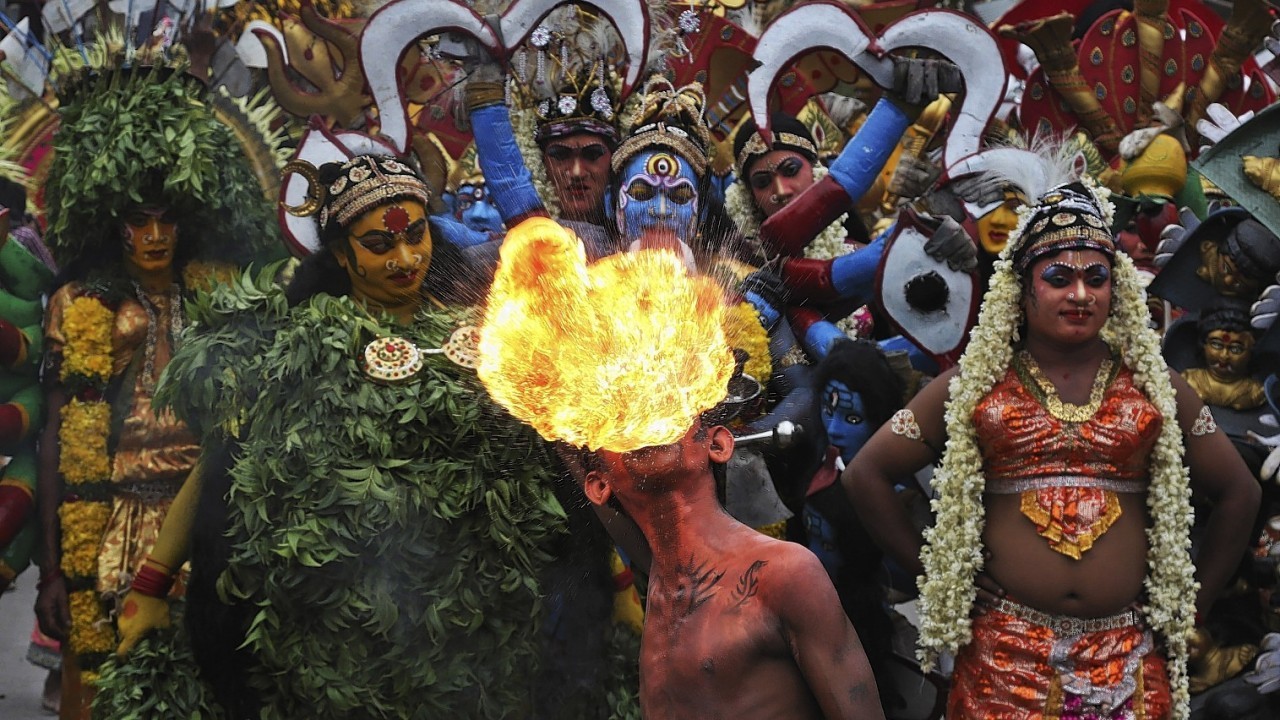 An Indian artist performs with fire during a procession as part of "Bonalu", a Hindu folk festival, in Hyderabad, India, Monday, July 21, 2014
