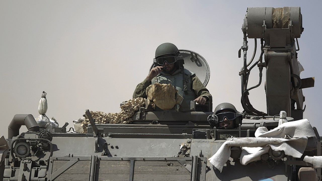 Israeli soldiers drive on an armored personal carrier near the Israel and Gaza Strip border, Monday, July 7, 2014