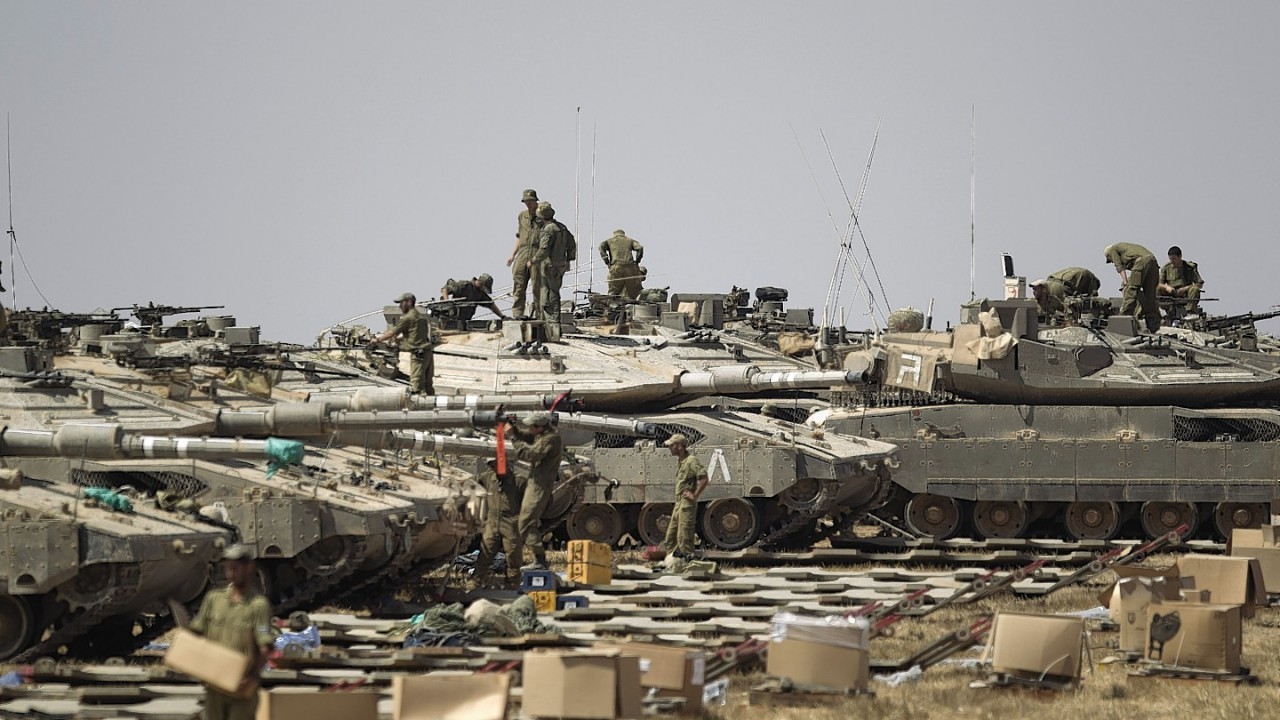 Israeli soldiers drive on an armored personal carrier near the Israel and Gaza Strip border, Monday, July 7, 2014