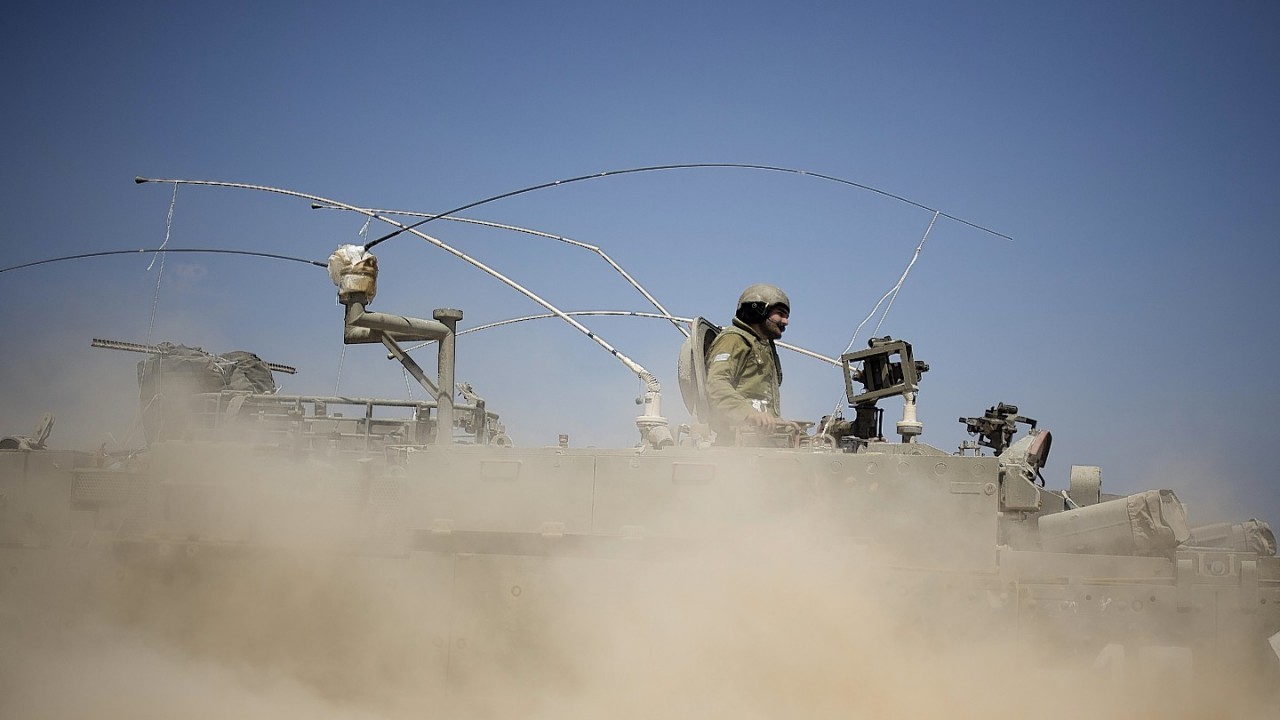 Israeli soldiers drive on an armored personal carrier near the Israel and Gaza Strip border, Monday, July 7, 2014