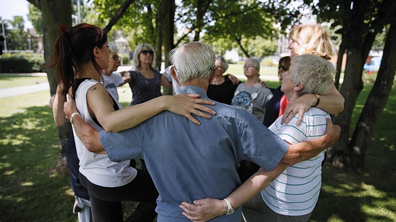 Jade Shaw, left, artistic director of Parkour Dance group, guides elderly people as they participate at a special parkour class at a park in south London.