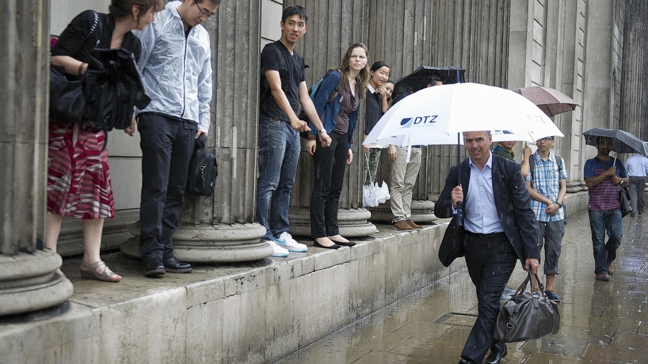 Members of the public get soaked as heavy rain falls in the City of London, London