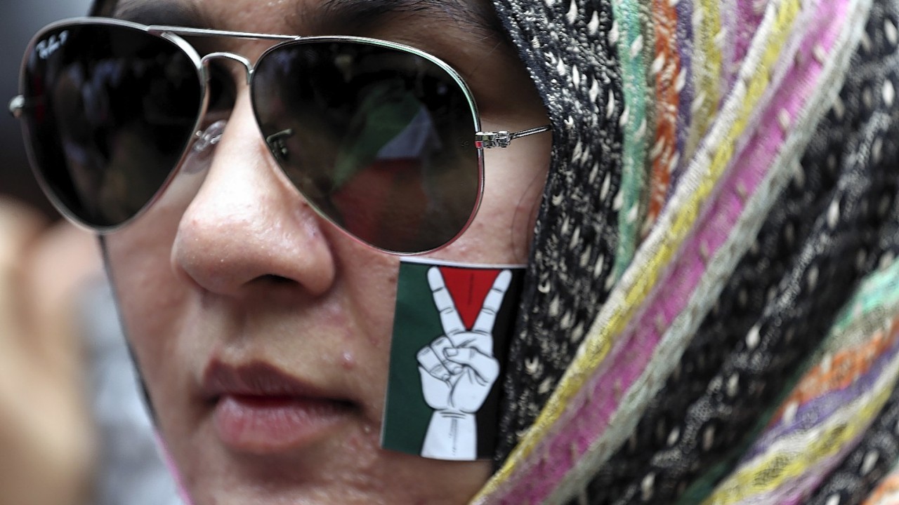 A Thai-Muslim activist puts a sticker on her face during a rally outside the Israeli embassy in Bangkok, Thailand. Several hundreds of activists took part in the rally to show solidarity for Palestine against Israel's attacks on Gaza